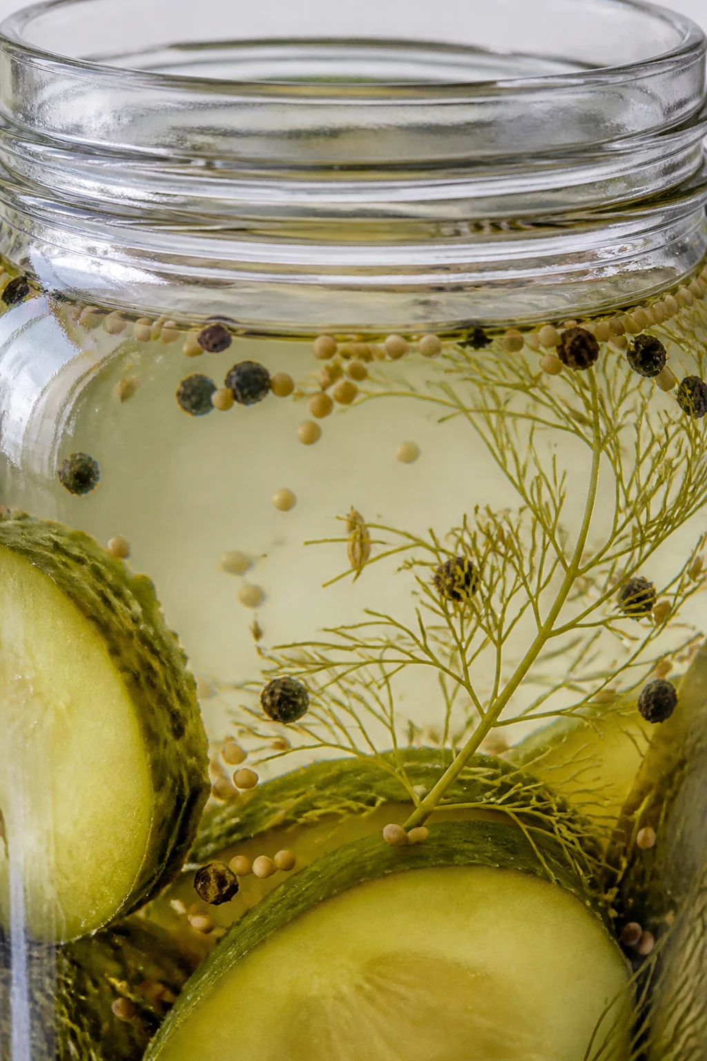 Closeup of crystal-clear pickle brine in glass jar