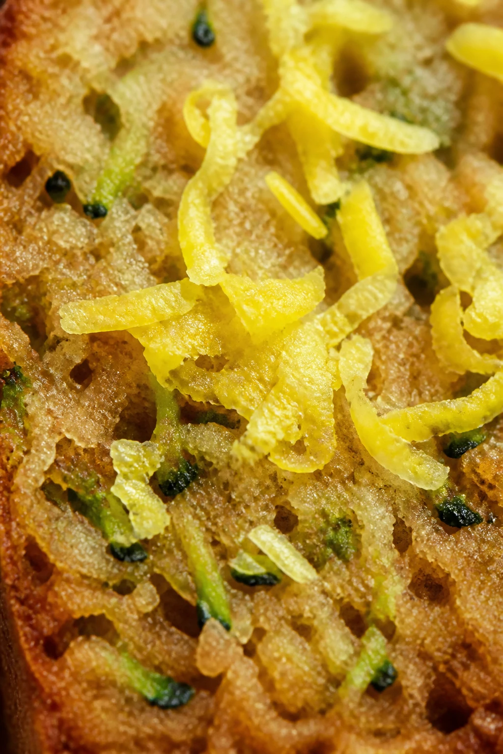 Closeup of lemon zest shavings atop zucchini bread crumb